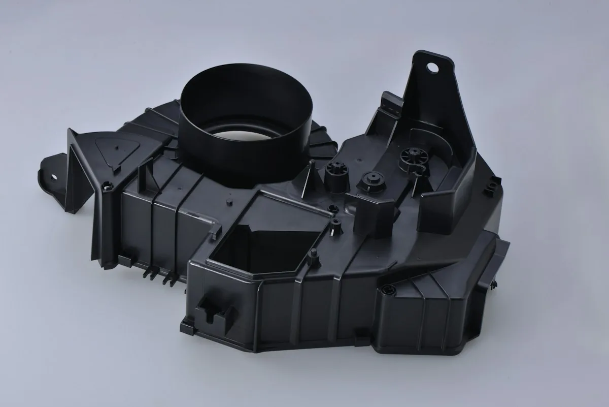 Reference photograph of a black molded plastic housing with ribs and mounting features; not an Omita product or customer project.